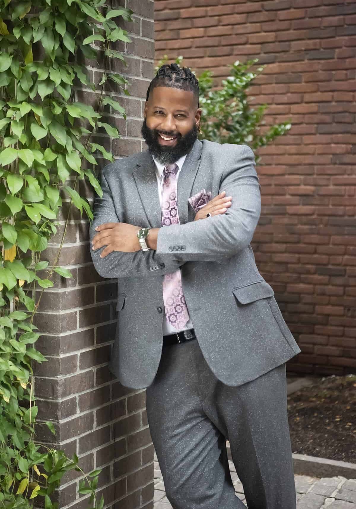 Randel Cross standing against wall with arms crossed